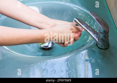 Hände waschen und den Wasserhahn aus der Tür drehen Stockfoto