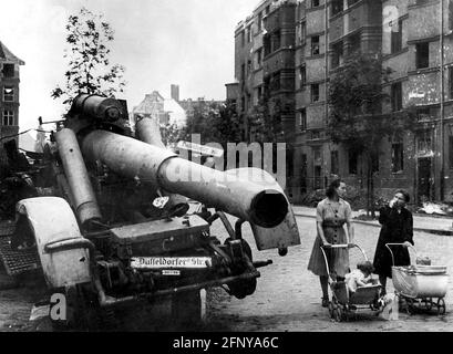 Nachkriegszeit, Städte, Berlin, zwei Frauen mit Kinderwagen neben einer zerstörten schweren deutschen Haubitze, Straßenschild 'Düsseldorfer Straße', REDAKTIONELLE VERWENDUNG Stockfoto