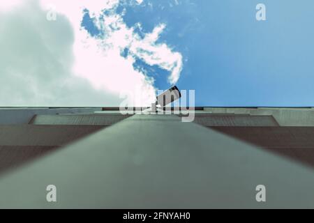Industriekamera an der Wand eines Betongebäudes mit Der Himmel im Hintergrund Stockfoto