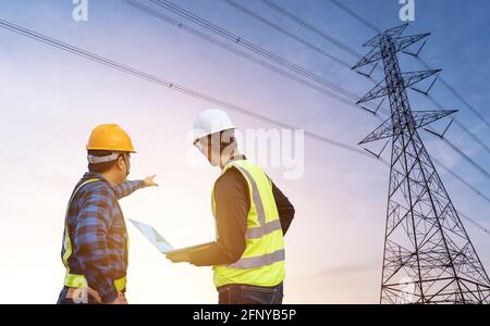 Zwei Elektroingenieure stehen und beobachten den Strom Station, um die Planungsarbeiten durch die Stromerzeugung bei zu sehen Hochspannungsstrom Stockfoto