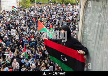 Maskierter Protestler hält Flagge über der Menge, Solidaritätsprotest „Freies Palästina“, London, 15. Mai 2021 Stockfoto