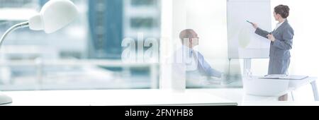 Zusammensetzung des Büroschreibtisches mit Lampe über Geschäftsfrau, die Präsentation gibt Im Büro Stockfoto