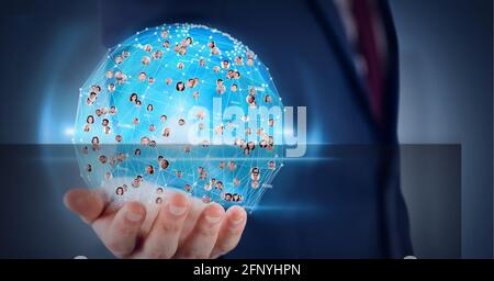 Globus aus Netzwerk von Profilsymbolen über die Hand des Geschäftsmannes Vor blauem Hintergrund Stockfoto