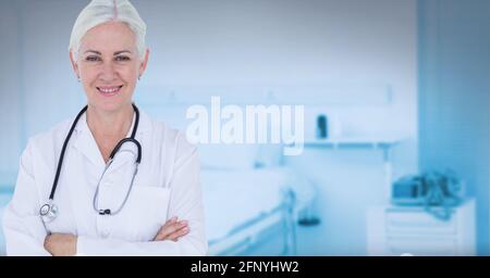 Porträt einer kaukasischen leitenden Ärztin, die gegen das Krankenhaus lächelt Hintergrund Stockfoto