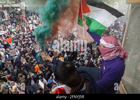 Demonstranten schwenken Flagge und halten eine Rauchbombe über der Menge, Solidaritätsprotest „Freies Palästina“, London, 15. Mai 2021 Stockfoto