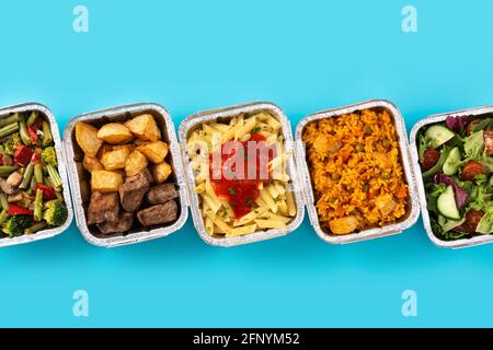 Nehmen Sie gesunde Lebensmittel in Folienkartons auf blauem Hintergrund mit Stockfoto