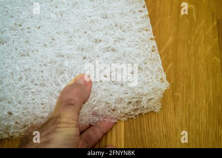POV männliche Hand mit neuer Polyethylen-Kunststoffmatratze Stockfoto