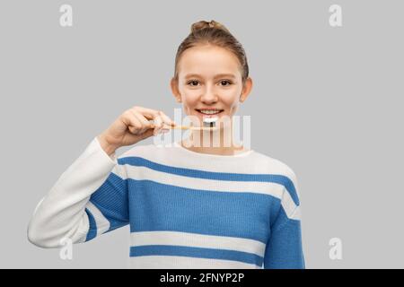 Fröhliches Teenager-Mädchen, das sich mit der Zahnbürste die Zähne putzt Stockfoto