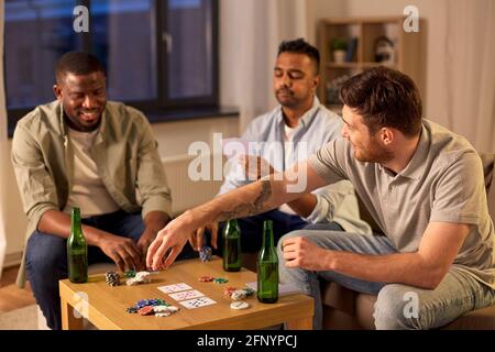 lächelnd männlichen Freunden Spielkarten zu Hause Stockfoto