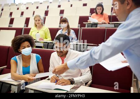 Lehrer und Schüler in Masken im Hörsaal Stockfoto