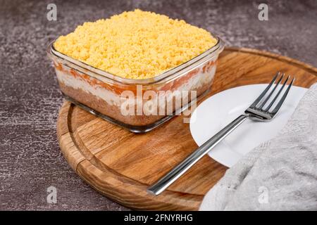 Traditioneller russischer Salat Mimosa mit Gemüse und Fisch. Geschichteter Salat mit Kartoffeln, Thunfisch, Karotten, Zwiebeln, Eiern und Mayonnaise. Stockfoto