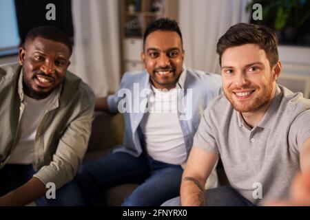 Glückliche männliche Freunde, die zu Hause Selfie machen Stockfoto