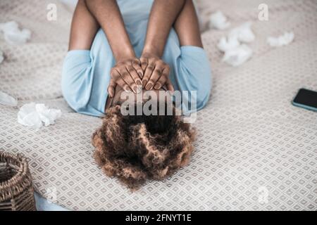 Weinende afroamerikanische Frau, die auf dem Bett liegt Stockfoto