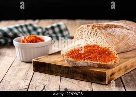 Toastbrot in Scheiben mit Sobrasada auf rustikalem Holztisch Stockfoto