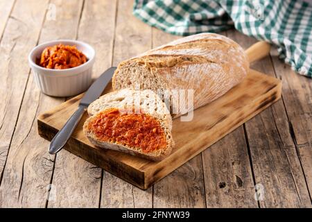 Toastbrot in Scheiben mit Sobrasada auf rustikalem Holztisch Stockfoto