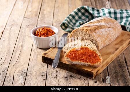 Toastbrot in Scheiben mit Sobrasada auf rustikalem Holztisch Stockfoto