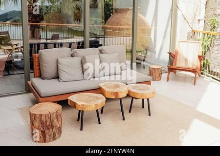 Holzsofa und Couchtische auf der stilvollen, modernen Terrasse Stockfoto