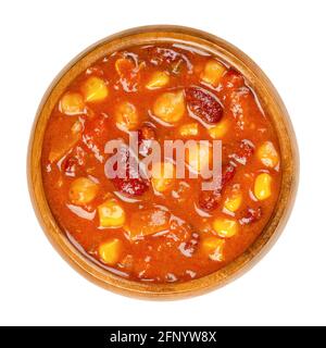 Vegetarisches Chili in einer Holzschüssel. Auch Chili sin Carne, ein würziger Eintopf mit Chilipulver, Tomaten, Nierenbohnen, Kichererbsen, Zwiebeln, Maiskörner. Stockfoto