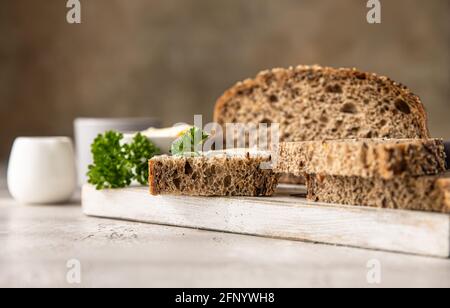 Frisch gebackenes, handgemachtes Mehrkornbrot mit Butter und Pastete. Frühstück mit Kaffee, Brotscheiben, Butter und Leberpastete. Hellgrauer Hintergrund. Stockfoto