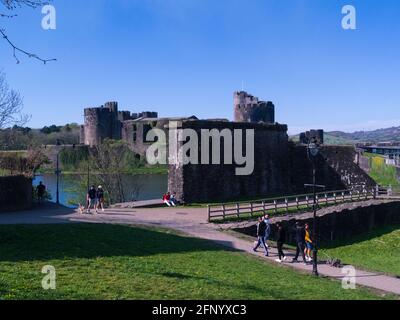 Besucher, die durch die Ruinen der Burg Caerphilly spazieren, die im 13 Gilbert de Clare an einem schönen Frühlingstag im April Stockfoto