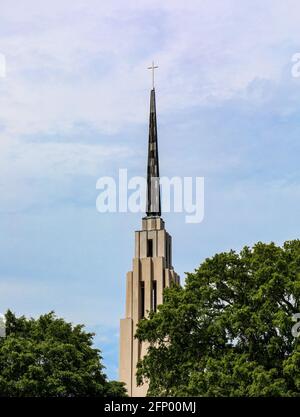 CHATTANOOGA, TN, USA-8. MAI 2021: Der erste hundertjährige Glockenturm und Kirchturm der Vereinigten Methodistischen Kirche. Nur der Turm, grüne Bäume und blauer Himmel in imag Stockfoto