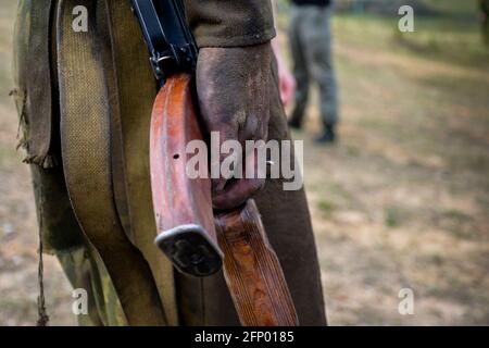 Weißrussland. 22,04,2014: Ein Maschinengewehr in der Hand eines schmutzigen Mannes. Armee, Spezialeinheiten, Militär, kastanienbraune Barette, Gerichtsverfahren. Spezialeinheiten-Soldaten werden auf das Recht getestet, eine kastanienbraune Baskenmütze zu tragen. Militär Stockfoto