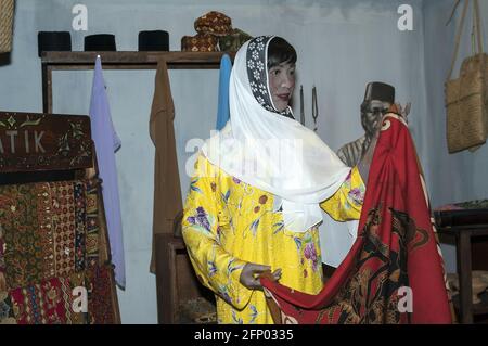 Singapur, Singapur, Asien, Asien; Sentosa - Museum: Bilder von Singapur; Museum: Bilder von Singapur; malaiische Frau, die Stoff kauft, Stockfoto