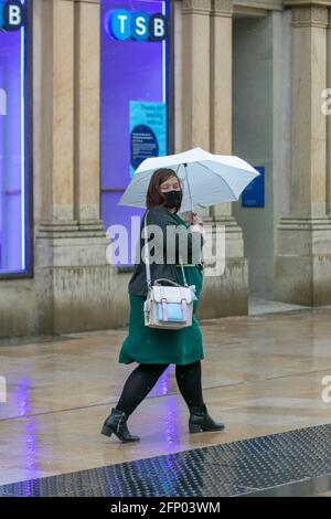 Frau, die an einem regnerischen Tag in Fishergate Preston, Lancashire, die TSB Bank passiert. Wetter in Großbritannien 20. Mai 2021. Kredit MWI/AlamyLiveNews Stockfoto