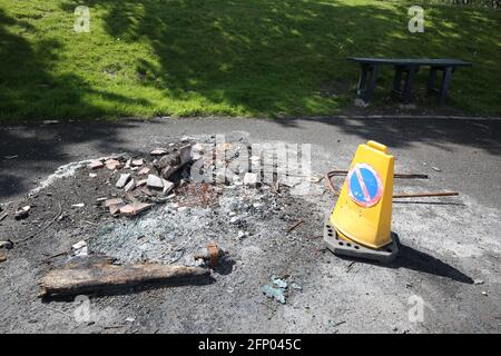 Mülltonne durch Feuer zerstört, das von Vandalen mit Verkehr aufgestellt wurde Kegel warnt Menschen vor der Gefahr Stockfoto