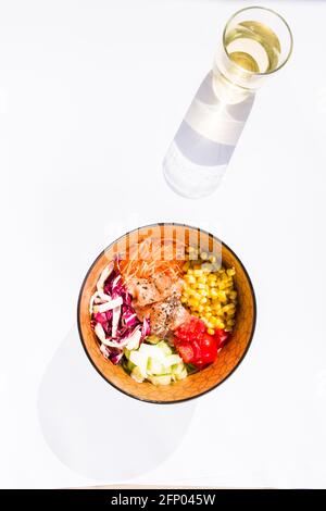 Verschiedene Poke Schüsseln mit Gemüse und Lachs o, Thunfisch, edamame Bohnen, auf einem weißen Hintergrund mit Essstäbchen und einem Glas weißem Whine, Draufsicht , Stockfoto