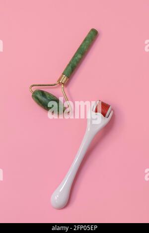 Draufsicht auf Mesoroller und grünen Jade Roller auf weich Rosa Hintergrund Stockfoto