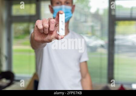Mann hält einen Covid-19-Heimtest, der einen negativen Test zeigt Ergebnis für Coronavirus Stockfoto
