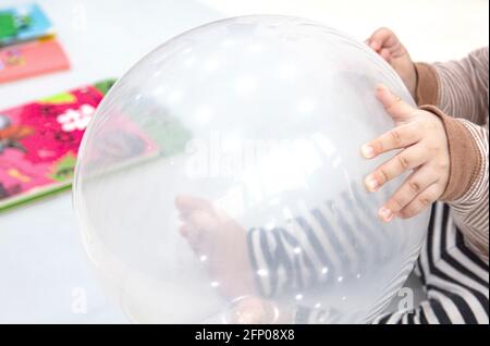 Ein großer weißer Ballon in der Hand des Kindes. Stockfoto