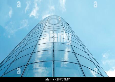 Fassade eines modernen Wolkenkratzers mit Spiegelung des wolkigen Himmels, Aufnahme in niedrigen Winkel, freier Kopierraum Stockfoto