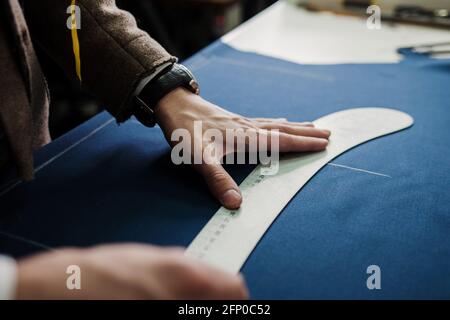 Schneidemaderstoff auf Skizzenlinie. Modedesigner Schneider oder Kanalisation in Werkstatt Studio Gestaltung neue Kollektion Kleidung. Geschäftsinhaber Shop A Stockfoto