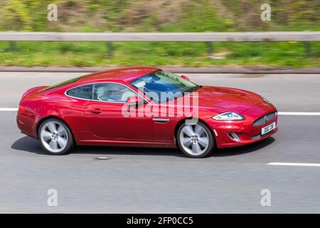 2014 roter Jaguar Signature XK; Fahrzeugverkehr, bewegliche Fahrzeuge, Autos, Fahrzeug auf britischen Straßen, Motoren, Fahren auf der Autobahn M6, britisches Straßennetz. Stockfoto