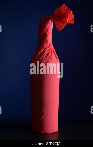 Rotpapier Wrap Weinflasche Shoot im Studio Stockfoto