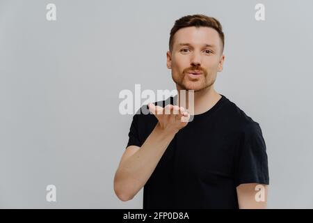 Junger hübscher Kerl, der Luftkuss auf die Kamera schickt Stockfoto