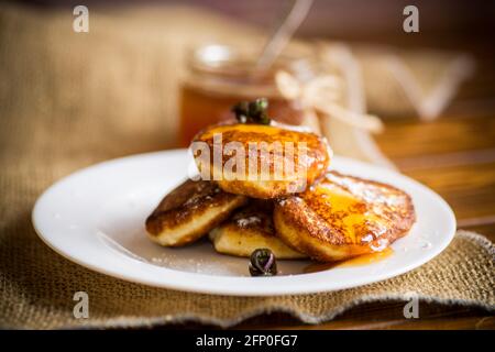 Süße gebratene Hüttenkäse-Pfannkuchen mit Marmelade auf einem Teller Stockfoto