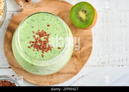 Entgiften Sie grünen Smoothie mit Grünkohl, Spinat und Kiwi auf hellgrauem Schiefer, Stein oder Beton. Draufsicht mit Kopierbereich. Stockfoto