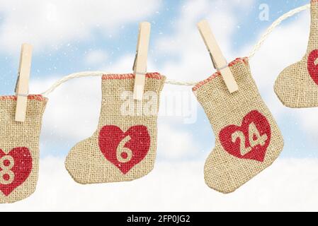 der weihnachtskalender hängt in der Schneelandschaft am Seil Stockfoto