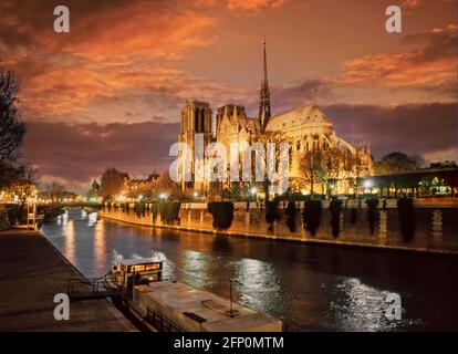 Französische Archivaufnahmen aus den 1990er Jahren, Abenddämmerung und Sonnenuntergang am Himmel über der beleuchteten historischen Kathedrale Notre Dame und dem Schiff, das auf der seine Paris France EU vertäut ist Stockfoto