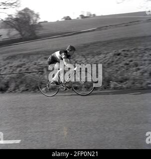 1960, historisch, in der Radsportausrüstung der Ära, ein junger Amateur-Radsportler, der auf der Straße unterwegs ist, England, Großbritannien. Stockfoto