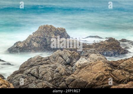 Felsen im pazifischen Ozean, gebadet von den Wellen, lange Exposition Stockfoto