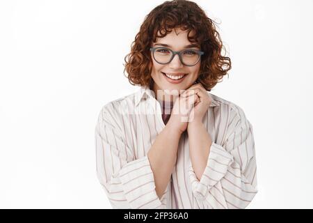 Nahaufnahme einer schönen jungen Frau in einer Brille, die koy und zärtlich in der Kamera aussieht, blushing, flirtete oder etwas schönes ansah, das romantisch stand Stockfoto