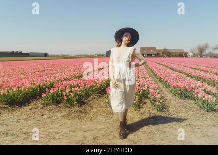 Porträt einer Frau, die auf Tulpenfeldern steht Stockfoto