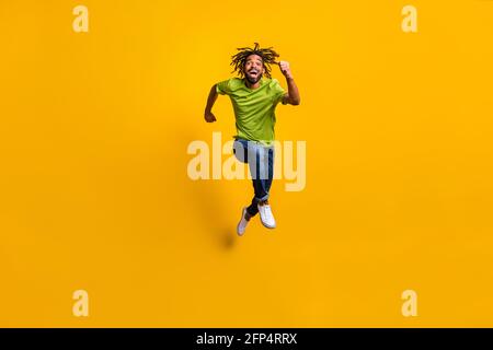 In voller Länge Foto Porträt des Mannes läuft vorwärts lachend springen Isoliert auf lebhaft gelbem Hintergrund Stockfoto