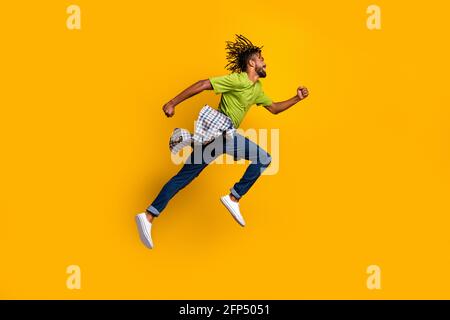Foto-Portrait Ganzkörper Seitenansicht des Mannes beim Springen Isoliert auf lebhaft gelbem Hintergrund Stockfoto