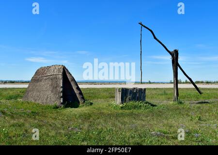 Österreich, traditioneller alter Ziehbrunnen und Jurte aus Stroh am winzigen See, Teil der eurasischen Steppe im Burgenland und Teil der internationalen Union für Kontra Stockfoto