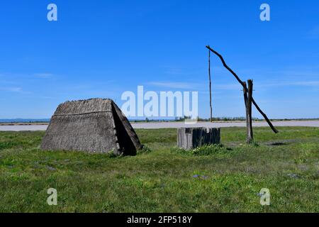 Österreich, traditioneller alter Ziehbrunnen und Jurte aus Stroh am winzigen See, Teil der eurasischen Steppe im Burgenland und Teil der internationalen Union für Kontra Stockfoto